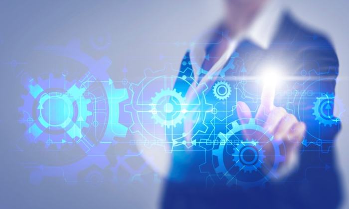 A worker using their finger to move a futuristic diagram of machinery.